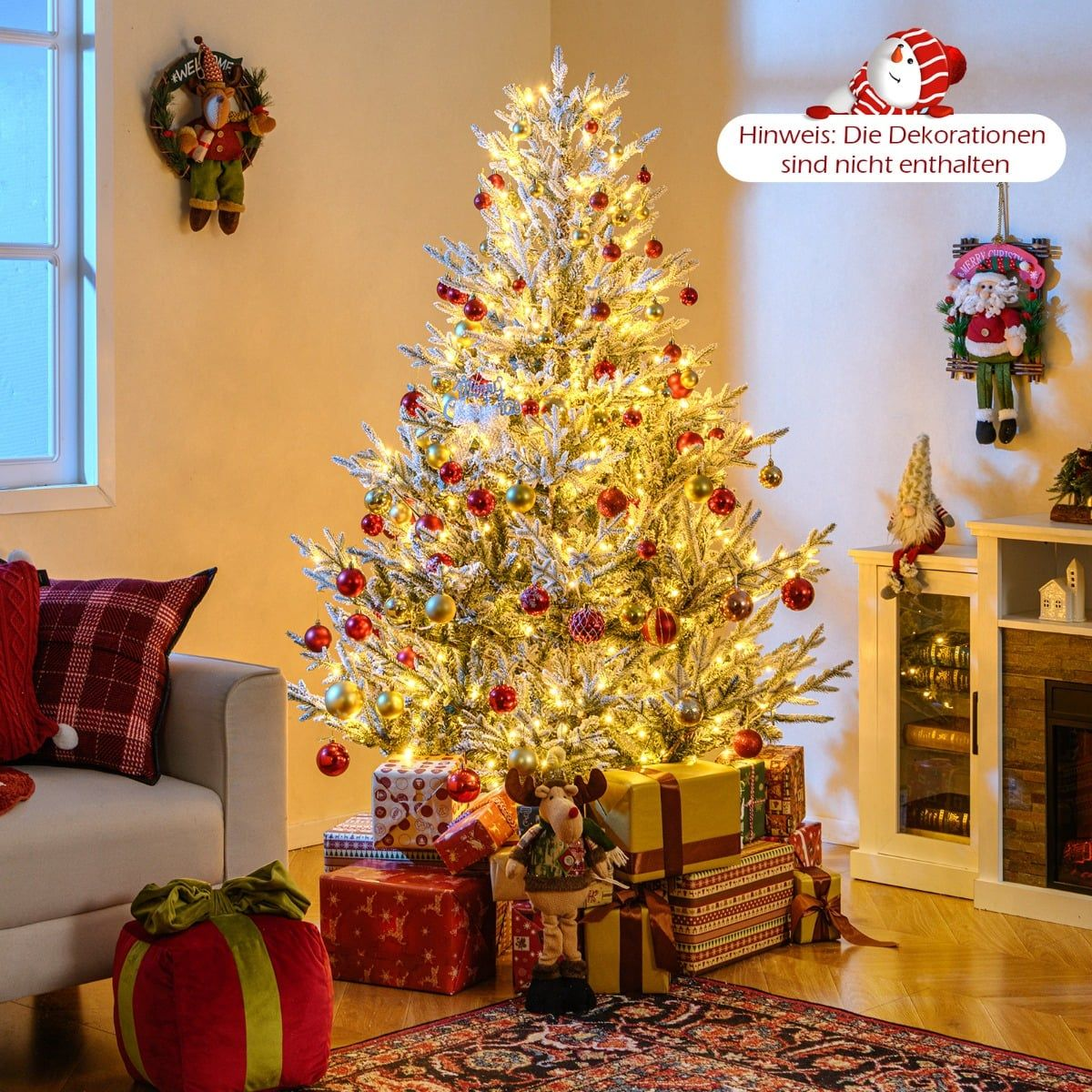 Een verlichte kerstboom met rode en gouden ornamenten, cadeaus en decoraties.