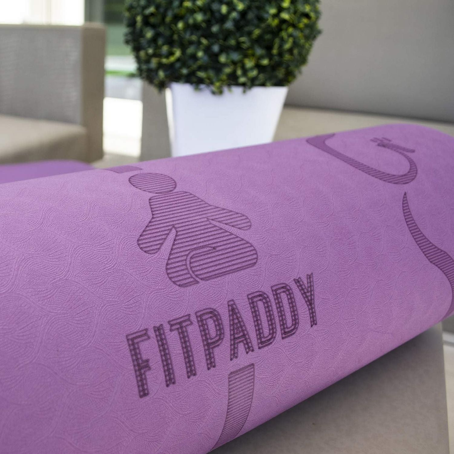 Paarse yogamat met "FITPADDY" tekst en persoonsiconen.