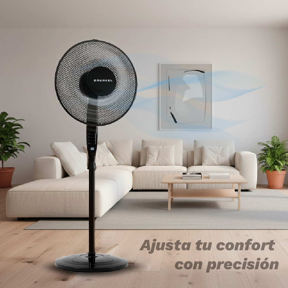 Un ventilador de pie negro está en una sala de estar con un sofá.