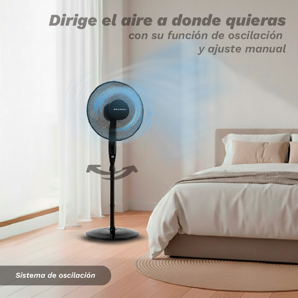 Un ventilador de pedestal negro oscilante está al lado de una cama.