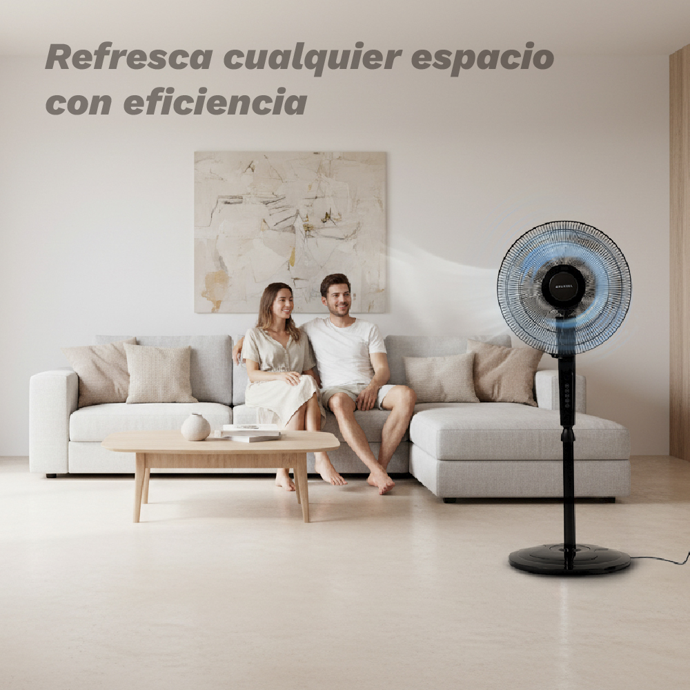 Una pareja se sienta en un sofá mientras un ventilador sopla aire.