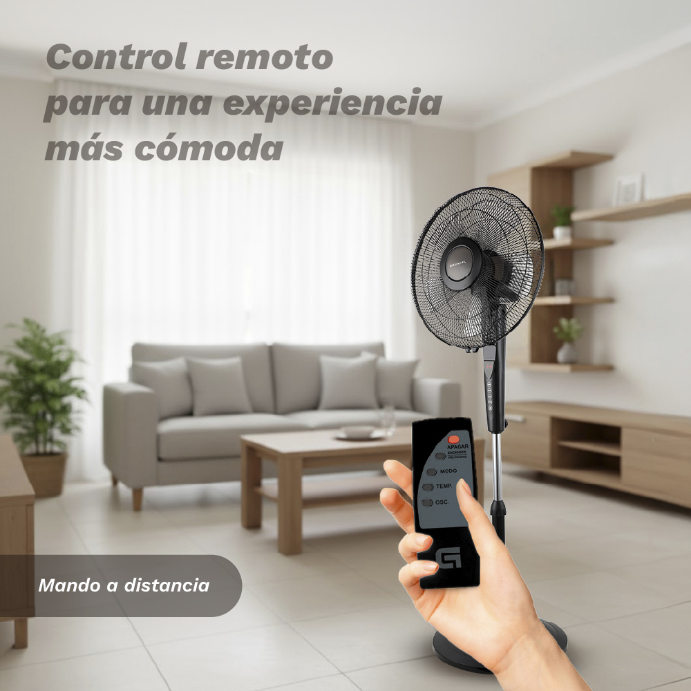Una mano sostiene un mando a distancia para un ventilador de pie en una sala.