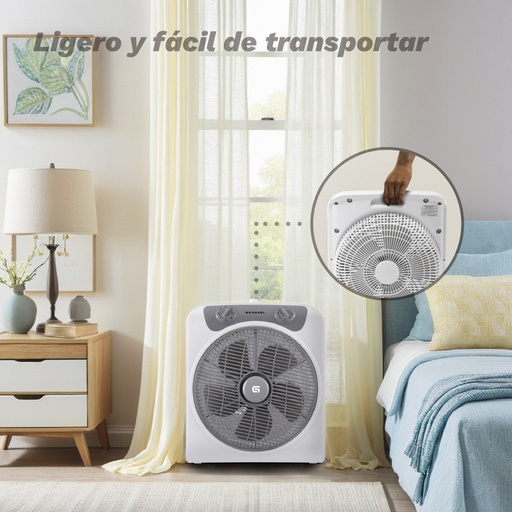 Un ventilador de caja blanco está en un dormitorio junto a una cama.