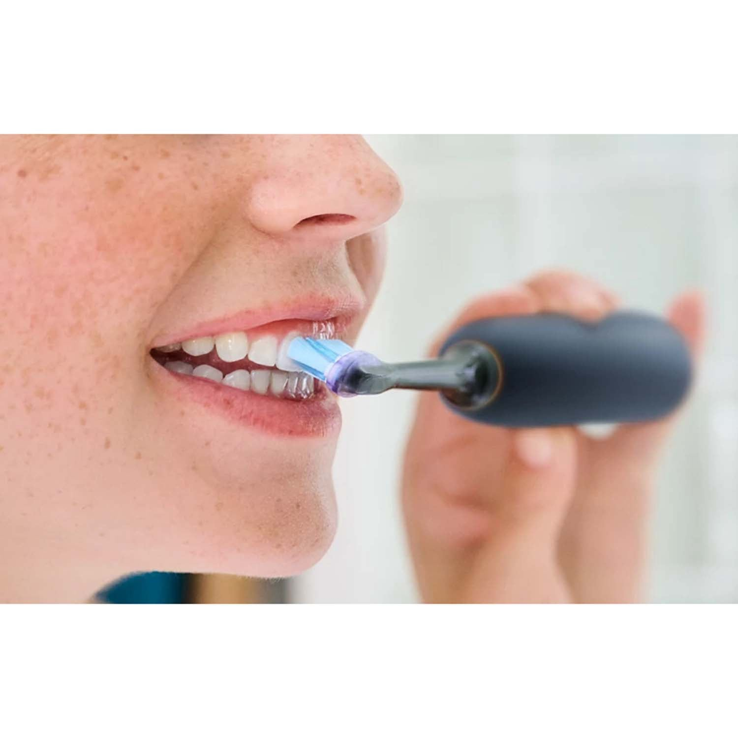 A person is brushing their teeth with an electric toothbrush.