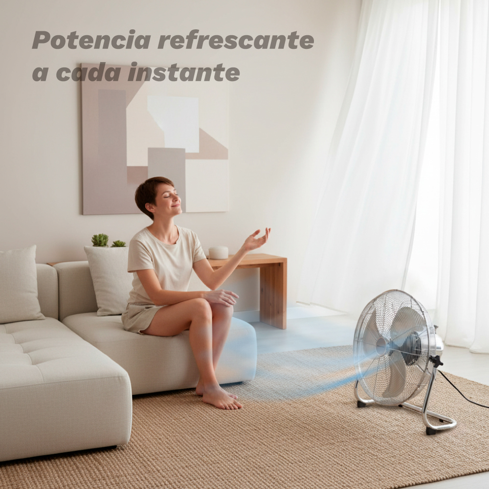Una donna seduta su un divano riceve aria fresca da un ventilatore.