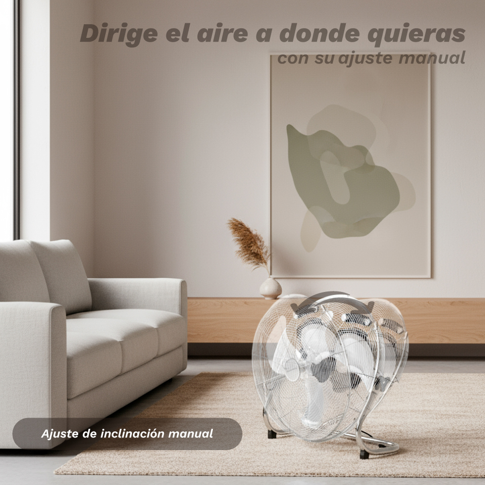 Un ventilatore d'argento su un tappeto davanti a un divano e un quadro.