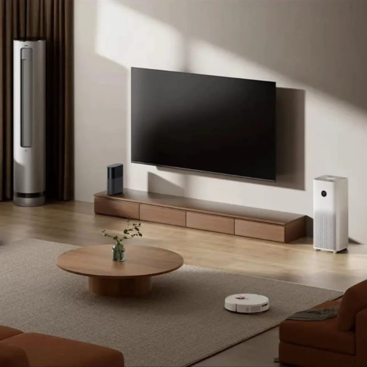 Woonkamer met tv, luchtreiniger, staande ventilator, salontafel en robotstofzuiger.