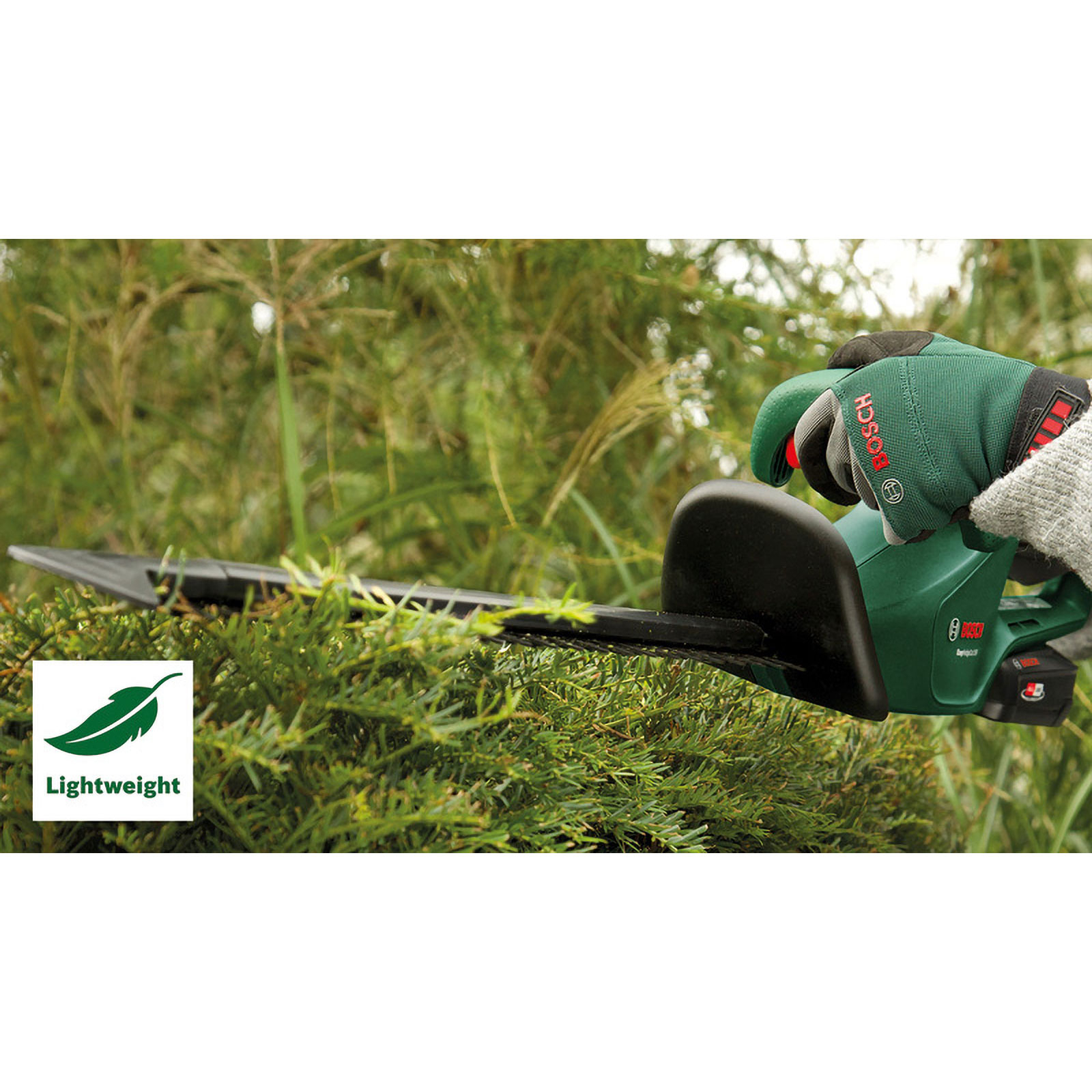Grüne Heckenschere schneidet Büsche, eine Hand mit Handschuh hält sie.