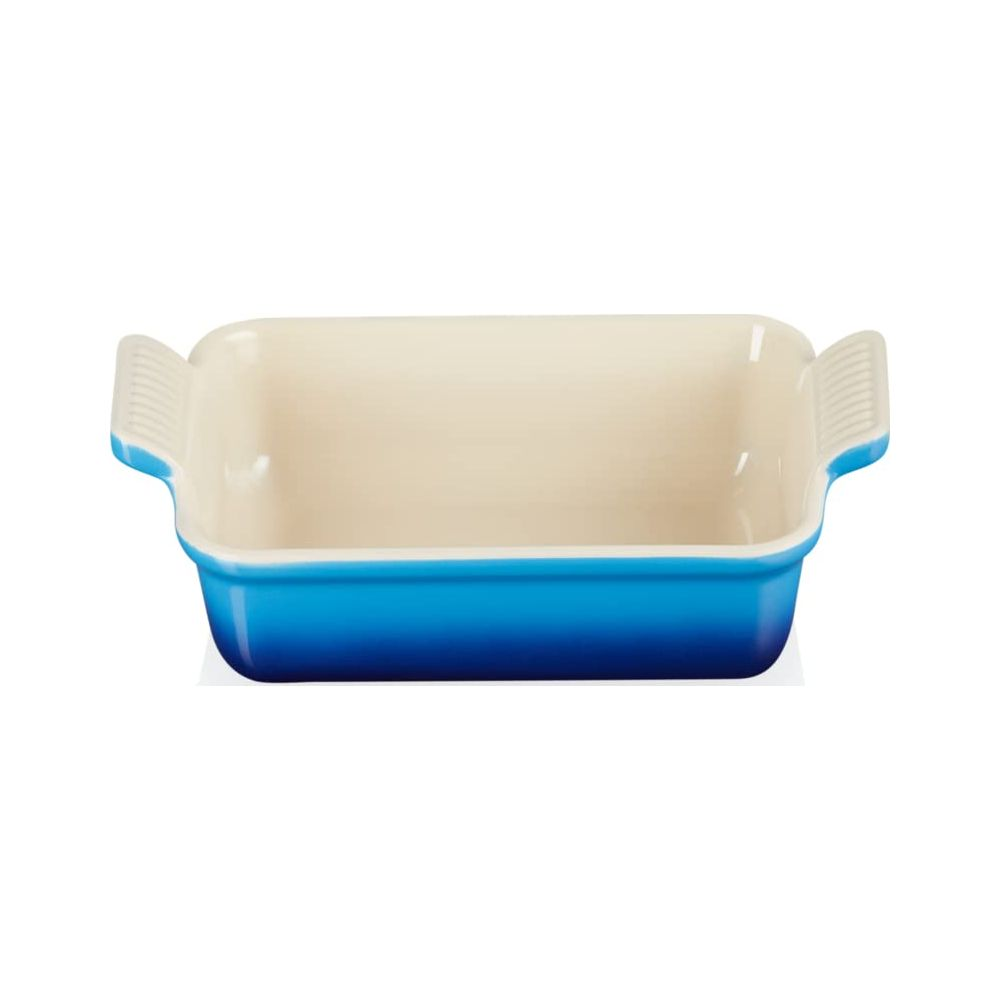 Eine blaue Keramikauflaufform mit cremefarbener Innenseite und Griffen.