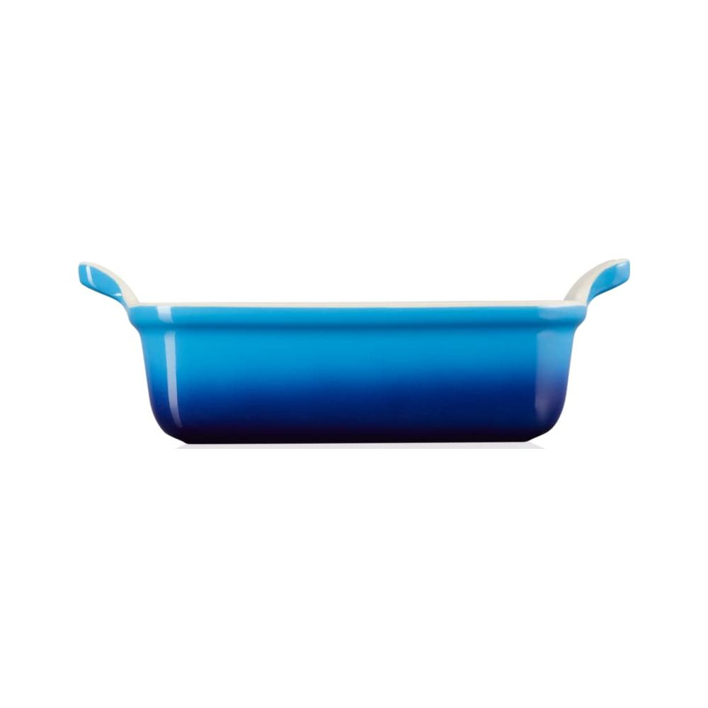 Eine blaue Keramikschale mit weißen Griffen auf weißem Hintergrund.