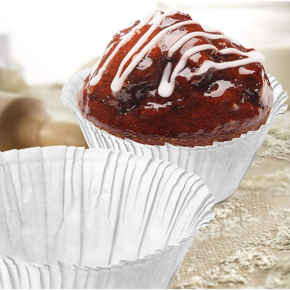 Ein brauner Kuchen mit Zuckerguss in einer Papierform.