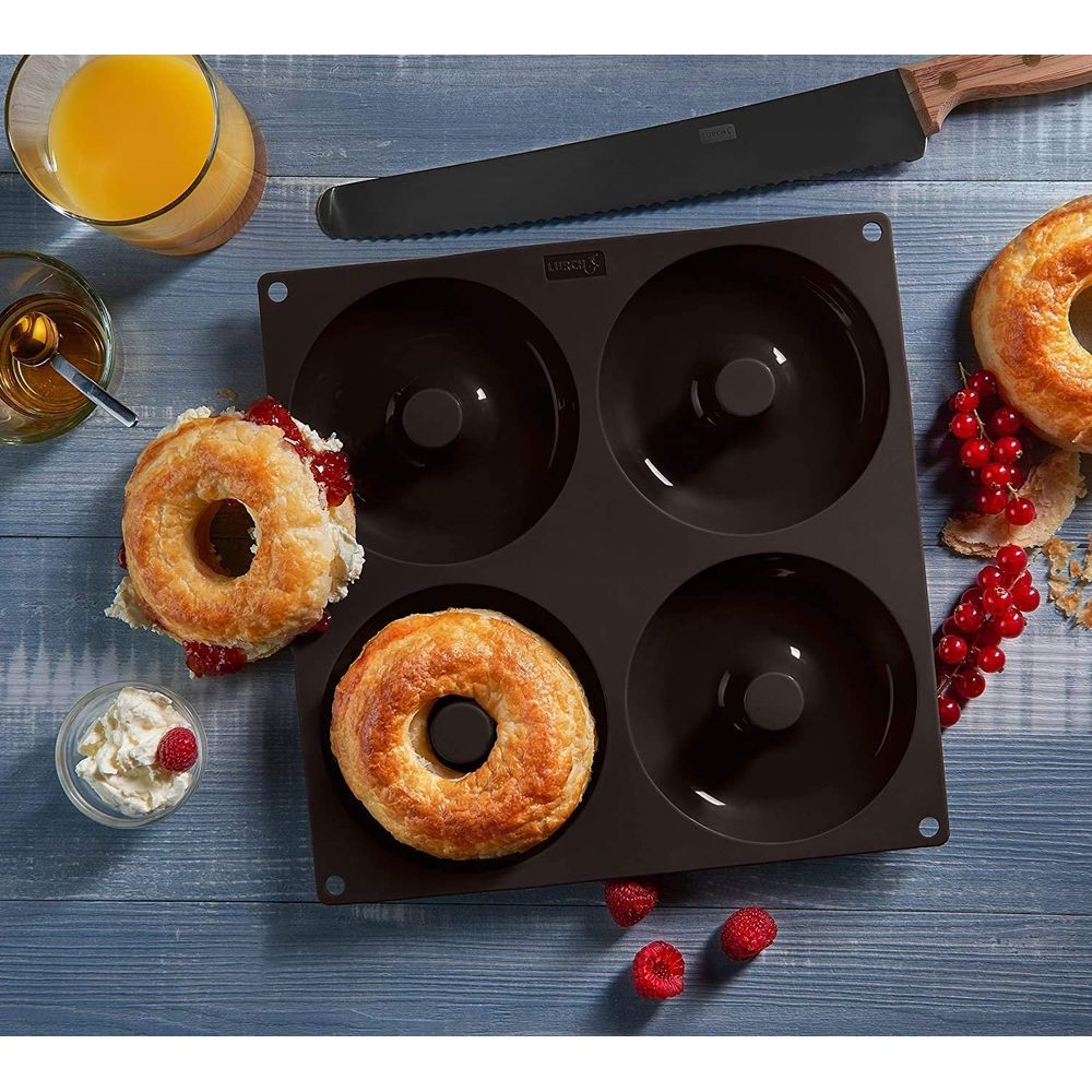 Ein Donut-Backblech mit zwei fertigen Donuts, Beeren und Orangensaft.