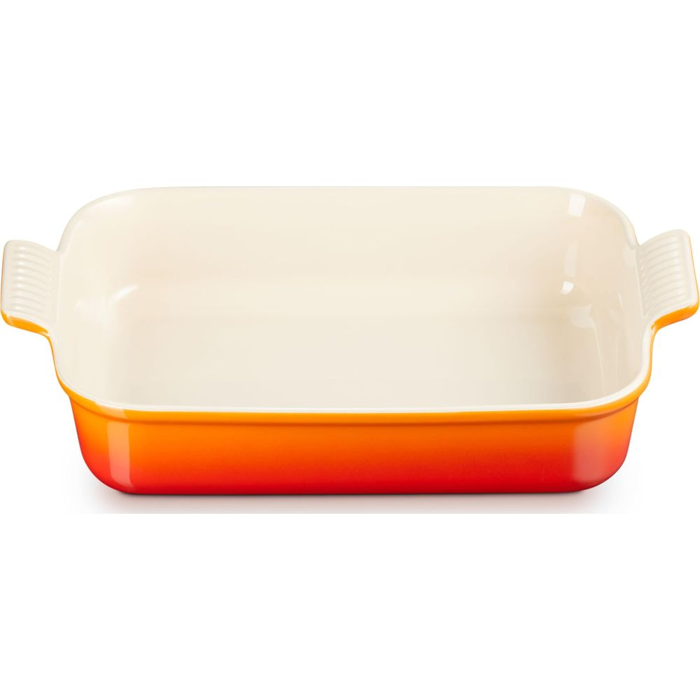 Eine rechteckige Auflaufform mit orangefarbenen Außenseiten und cremefarbener Innenseite.