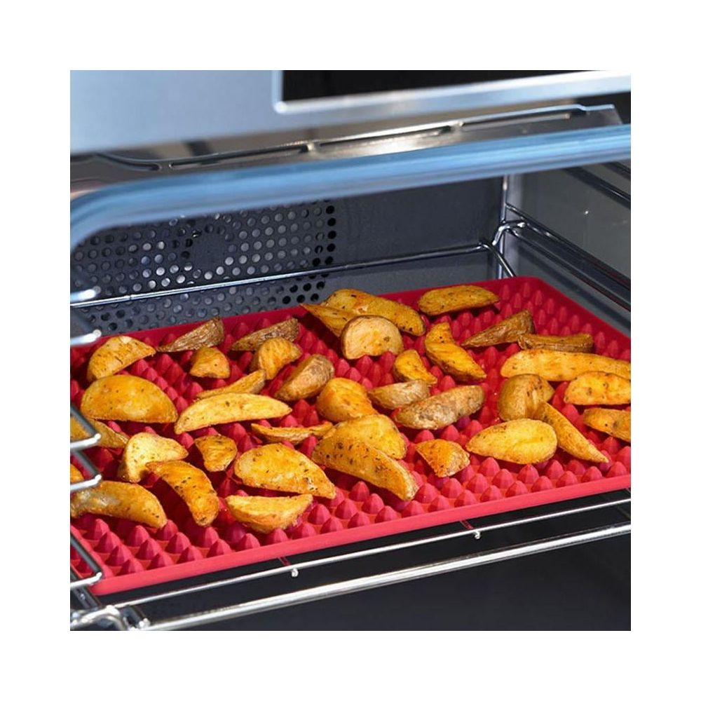 Quartiers de pommes de terre rôtis sur un tapis en silicone rouge dans un four.