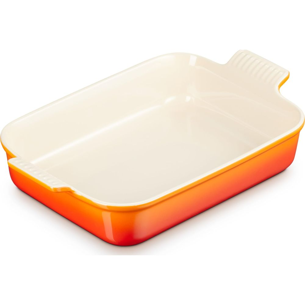 Eine rechteckige Auflaufform aus Keramik in leuchtendem Orange mit cremefarbener Innenseite.