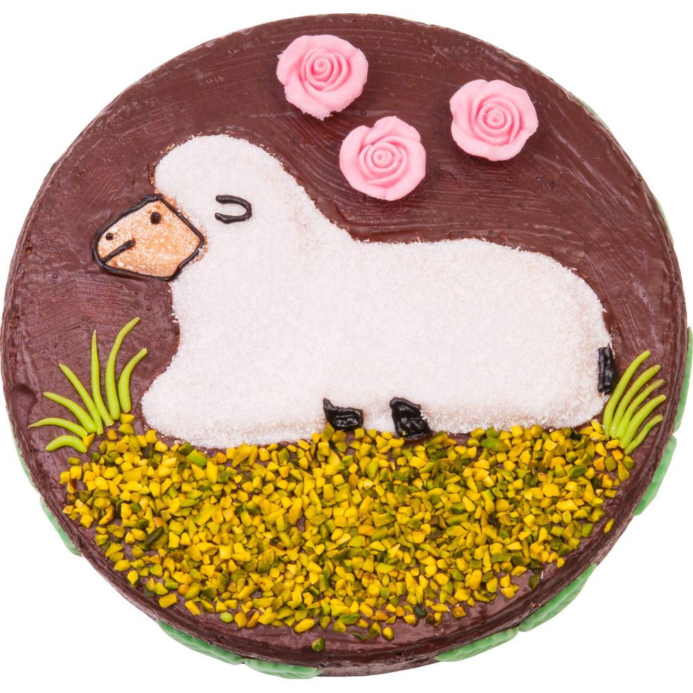Ein Schokoladenkuchen mit einem weißen Lamm aus Kokosraspeln, auf Pistazien und Blumen dekoriert.