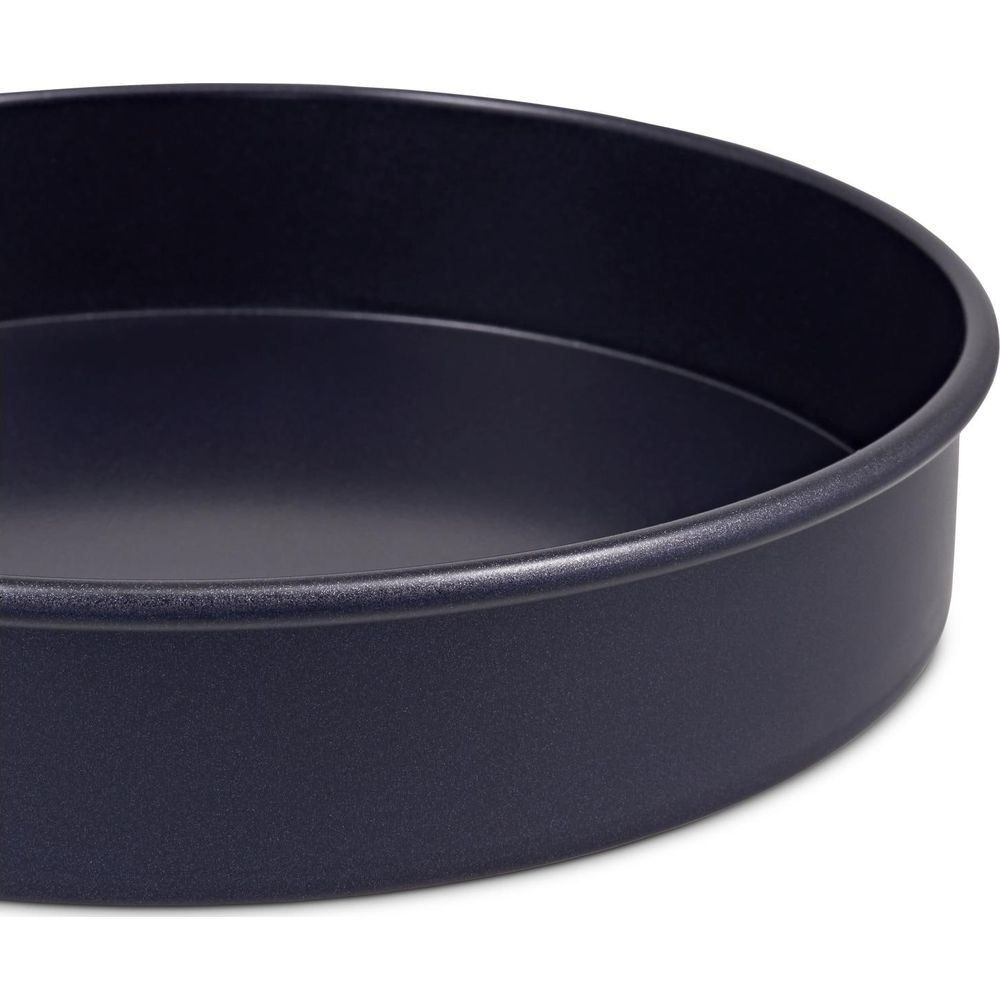 Eine dunkle, runde Kuchenform aus Metall mit glatten, abgeschrägten Rändern.