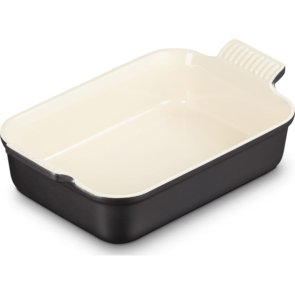 Un plat de cuisson rectangulaire foncé avec intérieur crème et poignées.