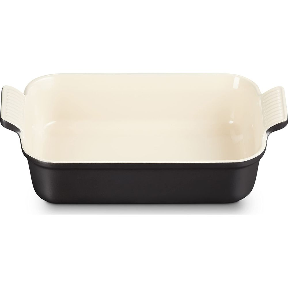 Un plat rectangulaire pour la cuisson, extérieur noir, intérieur crème.