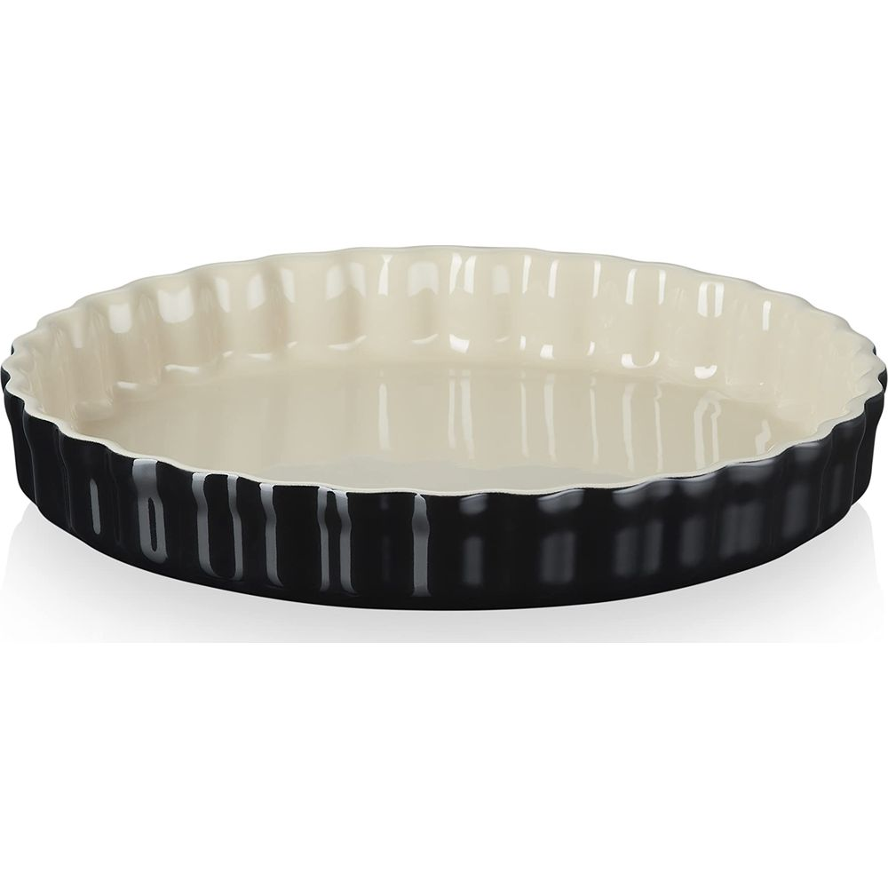 Eine schwarze Keramik-Tarteform mit cremefarbener Innenseite und geriffeltem Rand.