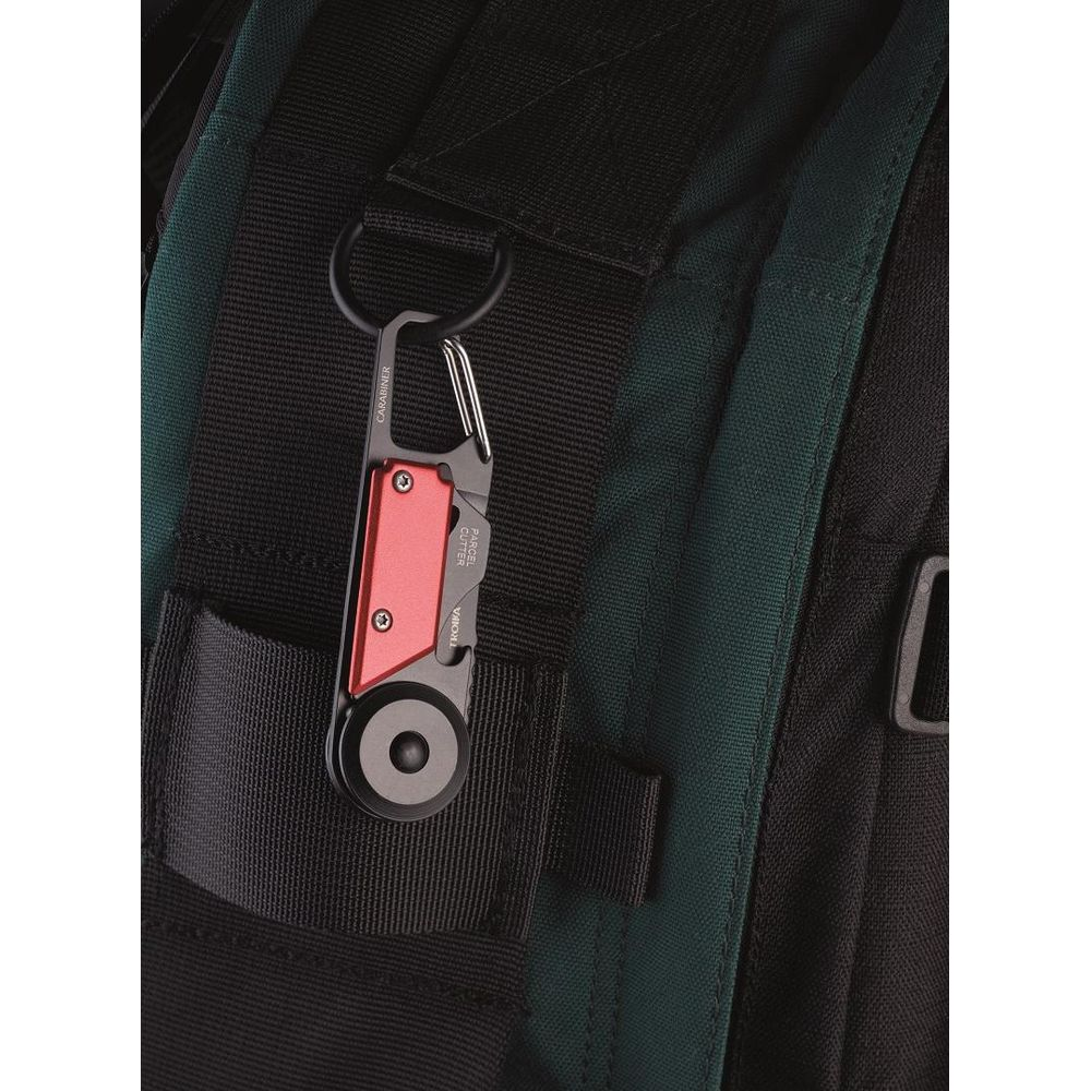 Ein rotes und silbernes Multitool mit Karabiner ist an einem Rucksack befestigt.