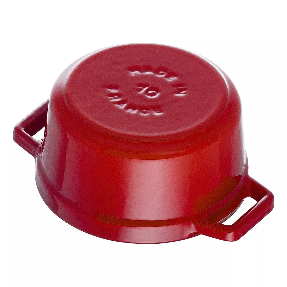 Casserole rouge avec anses, à l'envers, avec texte en relief.