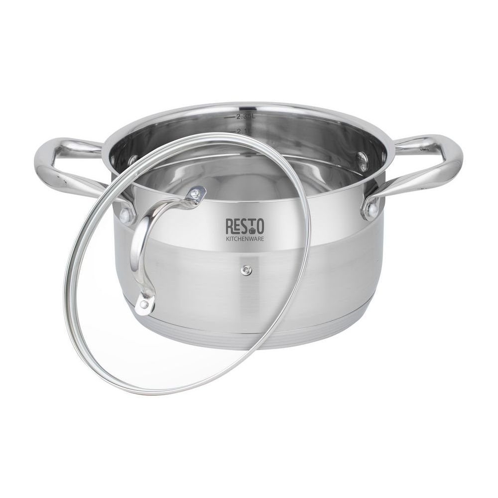Une casserole en acier inoxydable avec couvercle en verre et deux poignées sur fond blanc.