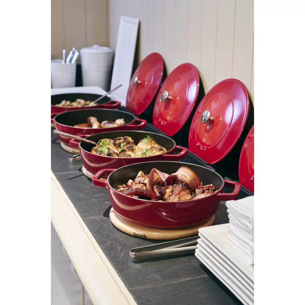 Casseroles rouges avec divers aliments sur un buffet.