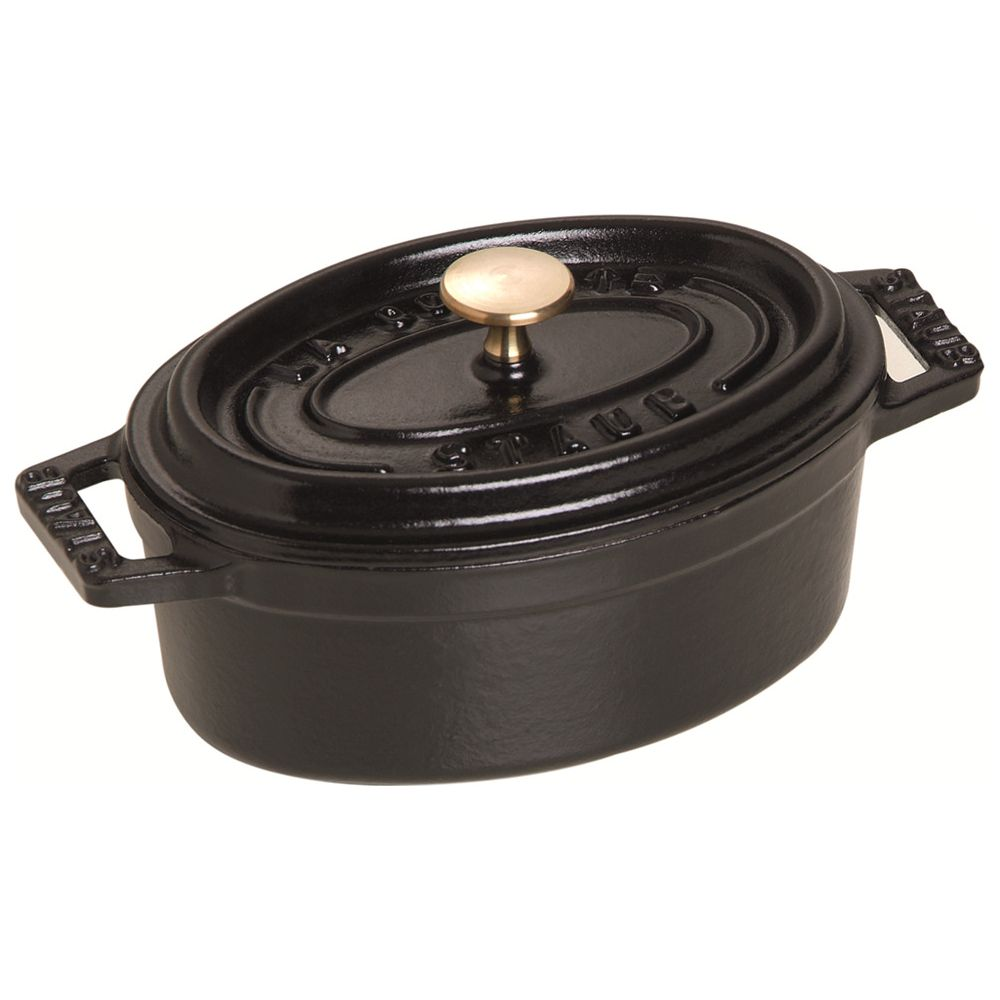 Marmite ovale en fonte noire avec un bouton doré sur le couvercle.