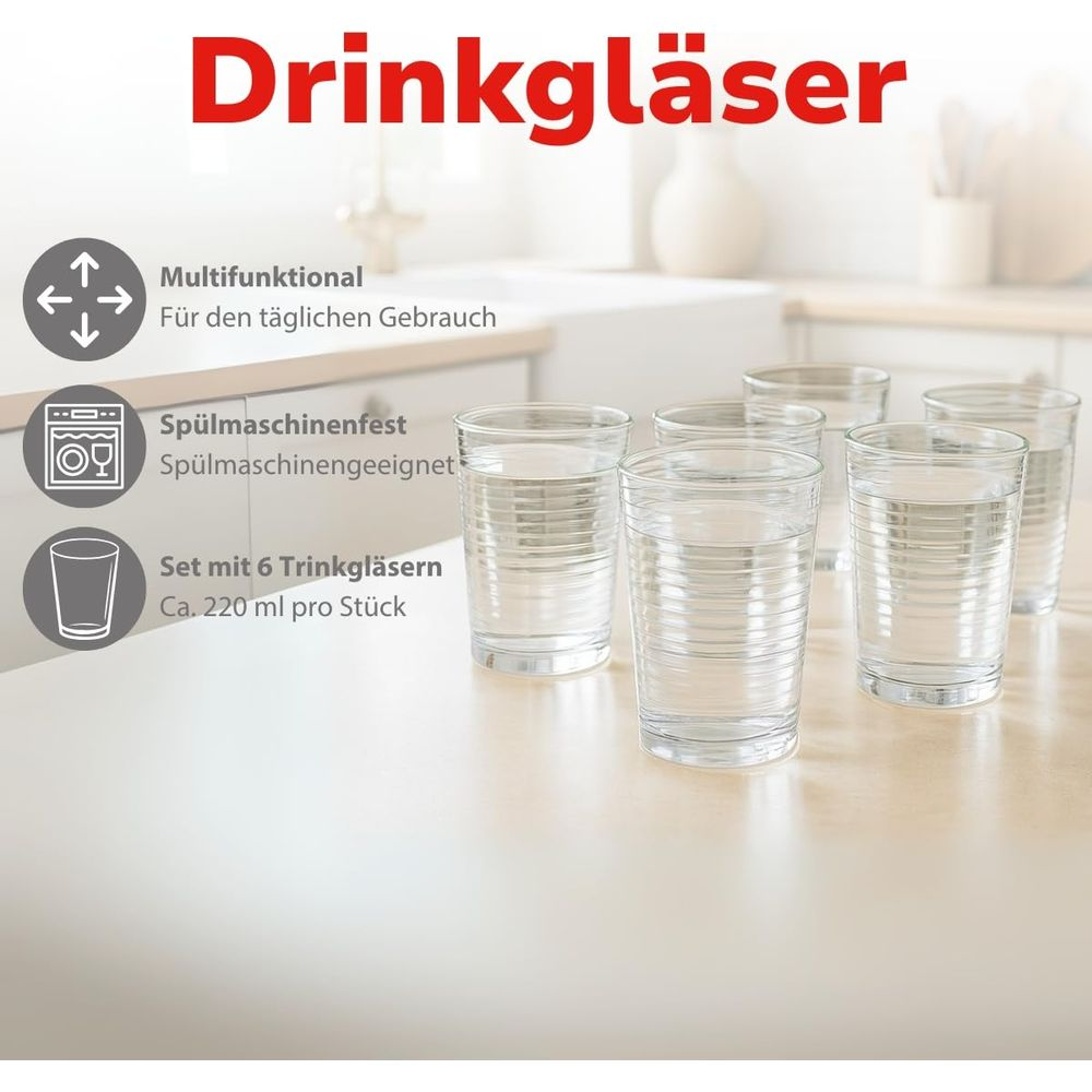 Sechs klare Trinkgläser mit Rillenmuster auf einem Tisch.