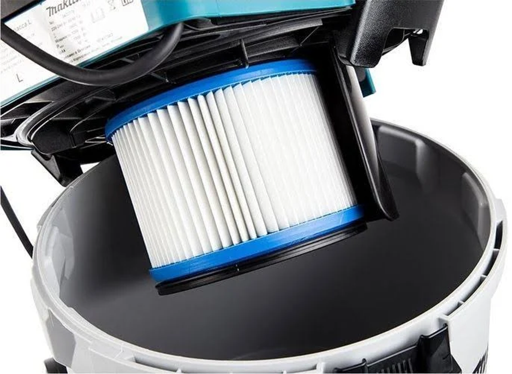 Un filtro bianco con bordi blu è dentro un contenitore per aspirapolvere grigio.
