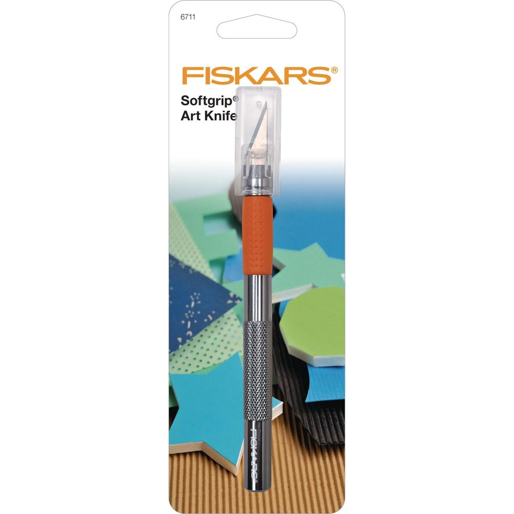 Fiskars Softgrip Art Knife mit orangefarbenem Griff und Klingenschutz, auf buntem Bastelpapier.