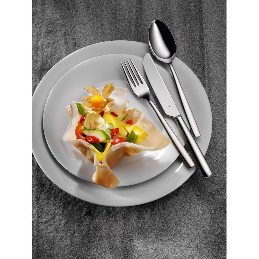 Ein Salat in einem knusprigen T¶llchen mit Obst und Gem¼se, daneben Besteck.