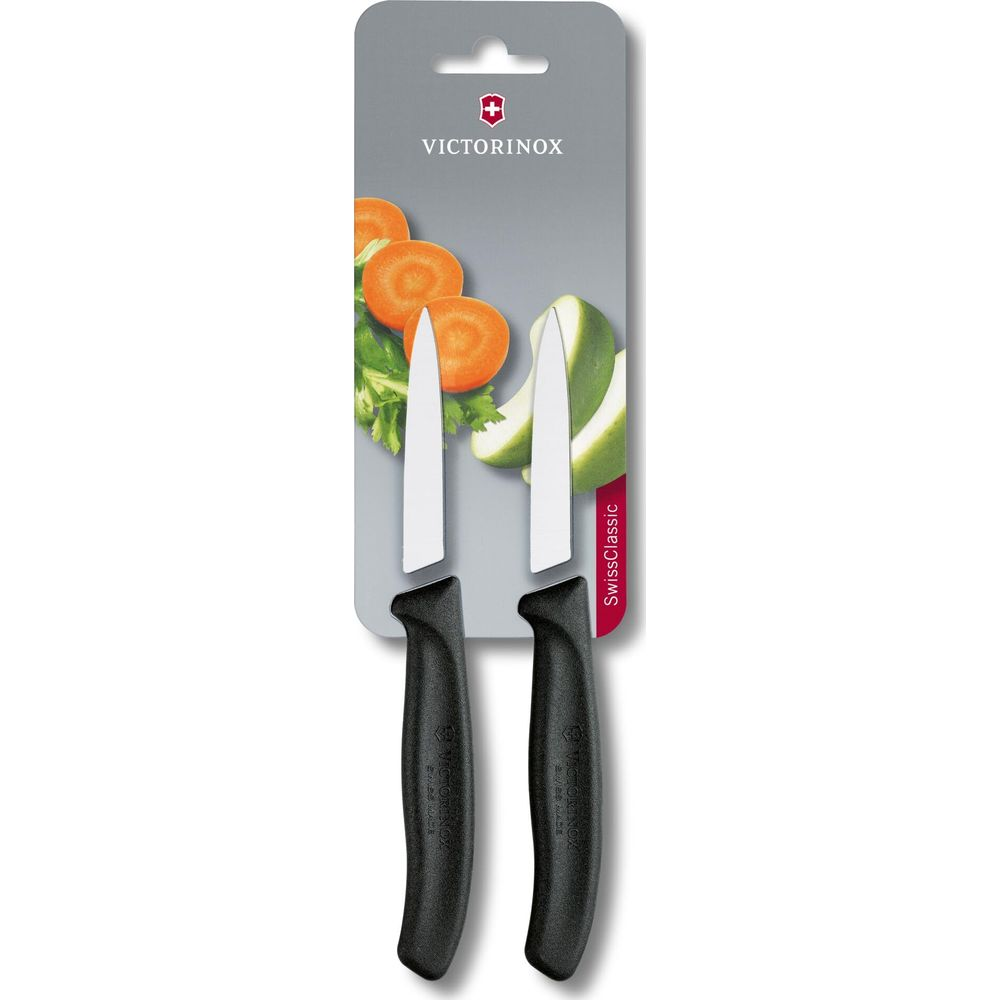 Zwei Victorinox Küchenmesser mit schwarzen Griffen und zwei geschnittenen Karotten und Gurken.