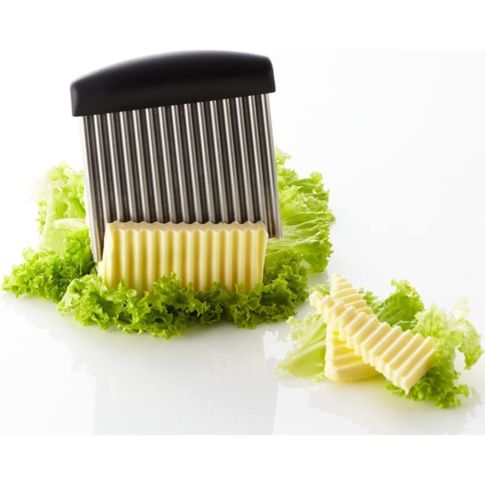 Ein Wellenschneider schneidet Butter auf Salatblättern.
