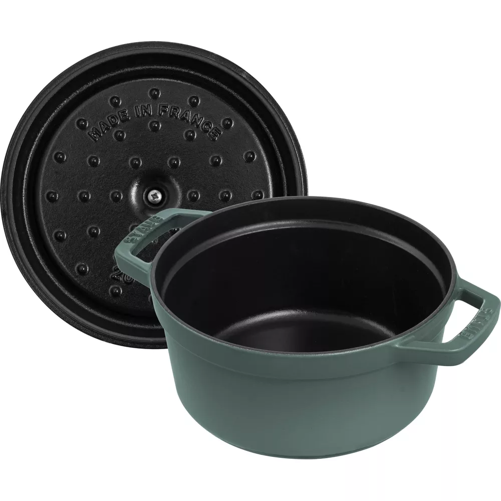 Ein grüner Gusseisentopf mit schwarzem Deckel, auf dem "Made in France" steht.