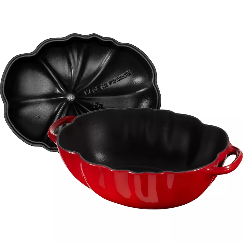 Marmite rouge en fonte en forme de citrouille avec couvercle noir.