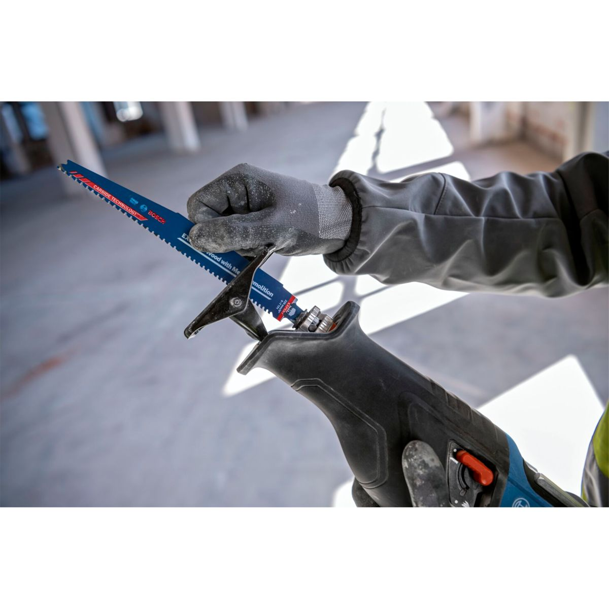 Eine Person mit Handschuhen setzt ein Sägeblatt in einen Reciprosäge ein.