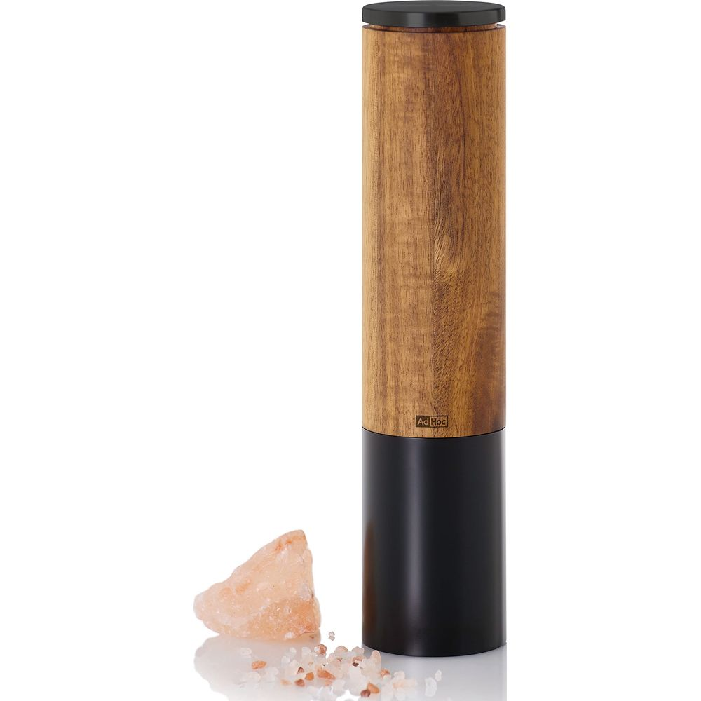 Holzmühle mit schwarzem Sockel neben rosa Salzkristallen.