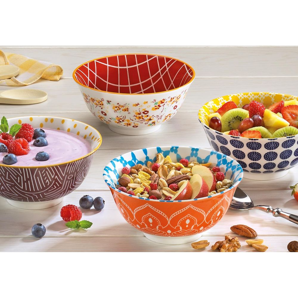Quattro ciotole per la colazione: yogurt, cereali, macedonia e una ciotola vuota.
