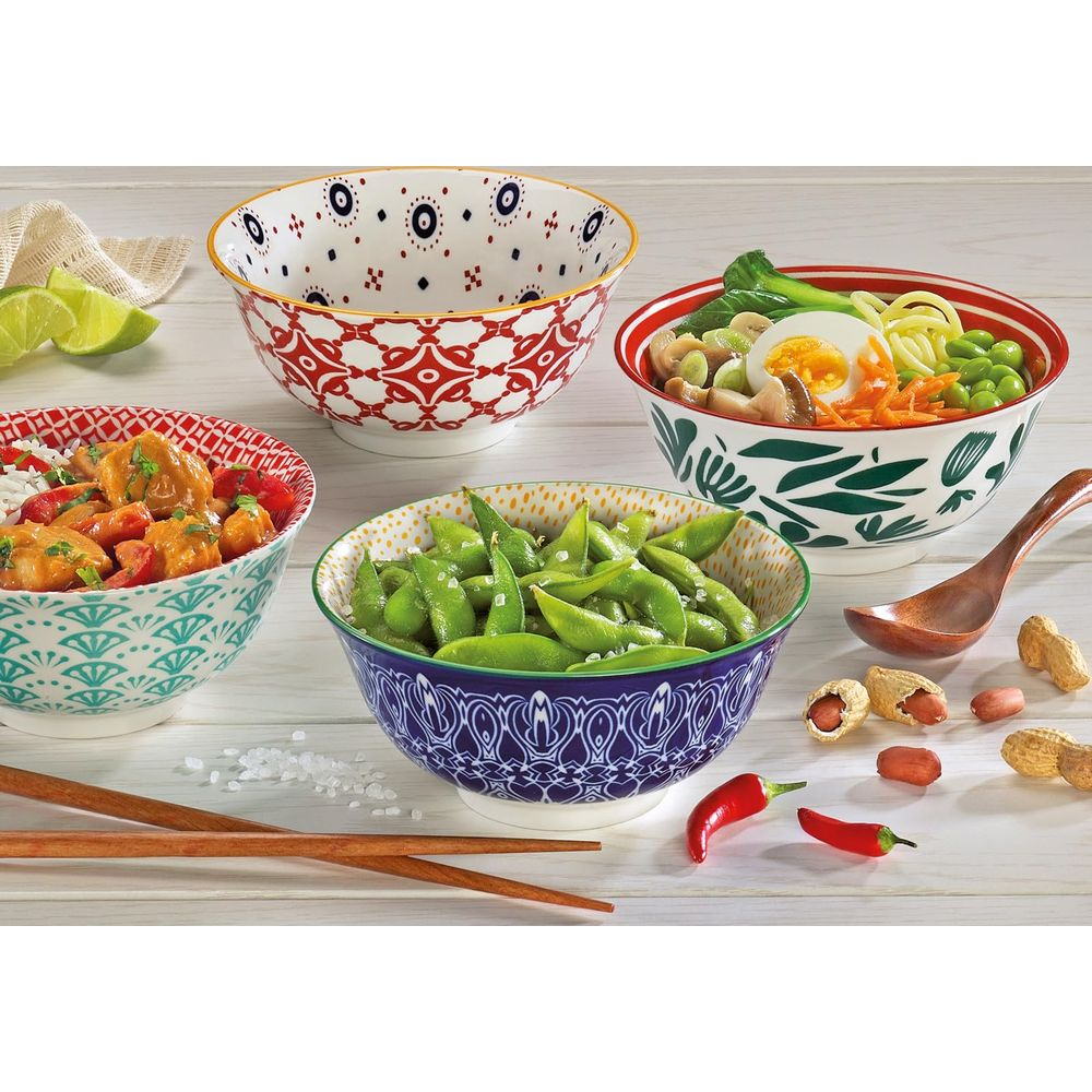 Quattro ciotole di cibo asiatico, lime, peperoncino e arachidi.