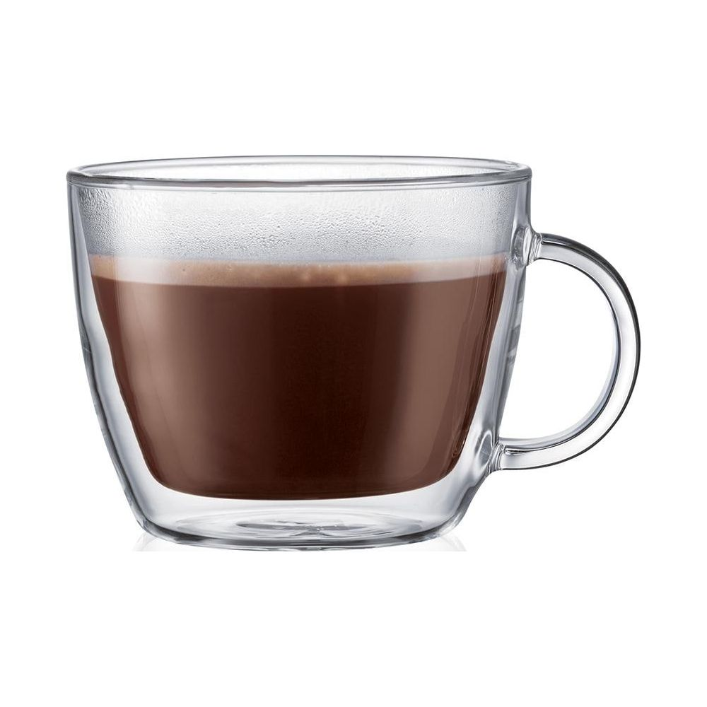 Eine klare Tasse mit braunem Getränk und Schaum.