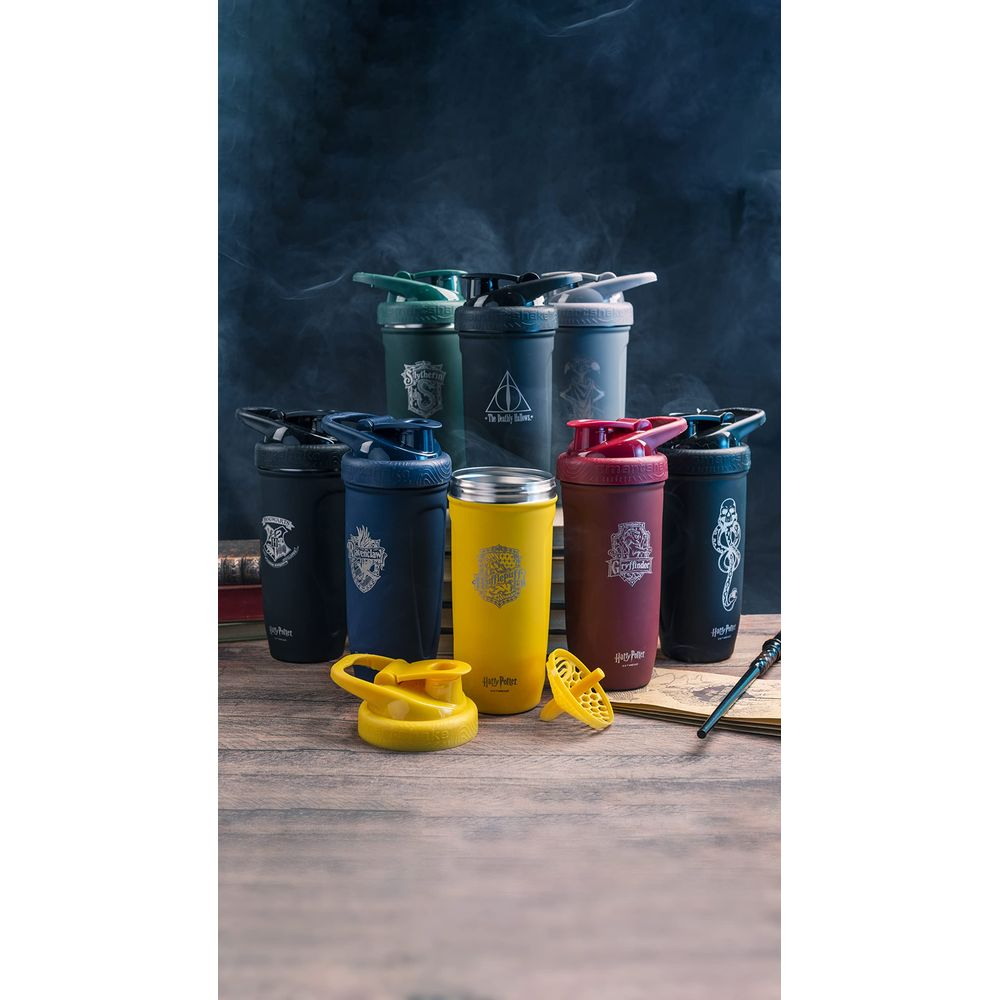 Eine Sammlung von Harry Potter Shaker-Flaschen in verschiedenen Farben und Designs, auf einem Holztisch.