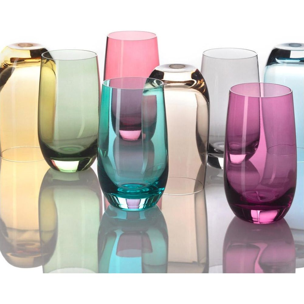 Mehrere bunte Glasbecher stehen nebeneinander, reflektiert auf einer weißen Oberfläche.