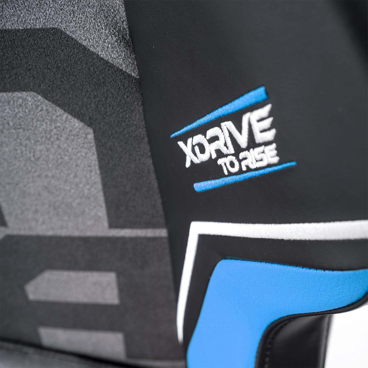 İşlenmiş "XDRIVE TO RISE" ve mavi-beyaz vurgulara sahip siyah yüzeyin yakın çekimi.