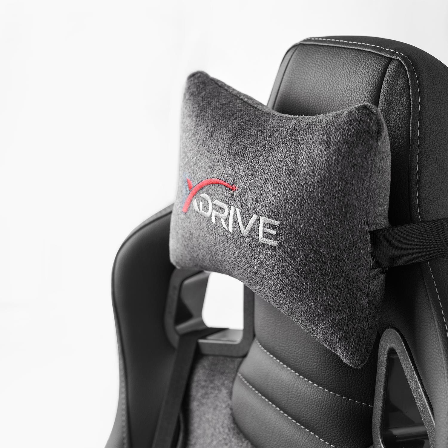 Kırmızı ve beyaz 'DRIVE' logosuna sahip gri yastıklı siyah oyuncu koltuğunun yakın çekimi.