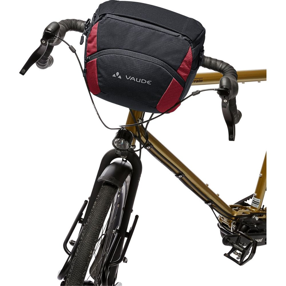 Sacoche de guidon Vaude noire avec accents rouges sur un vélo doré.