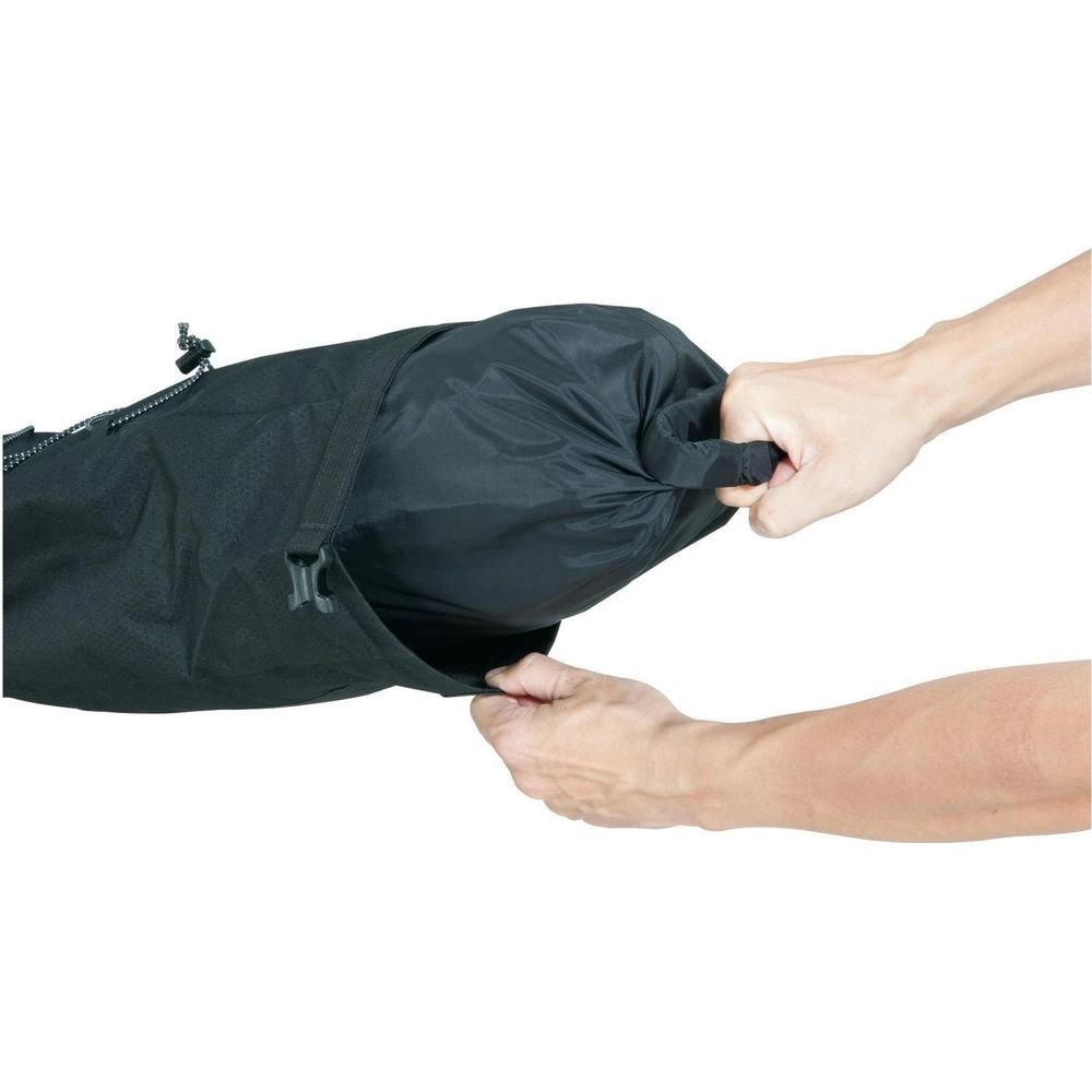 Mains fermant un sac en tissu noir. Gros plan.