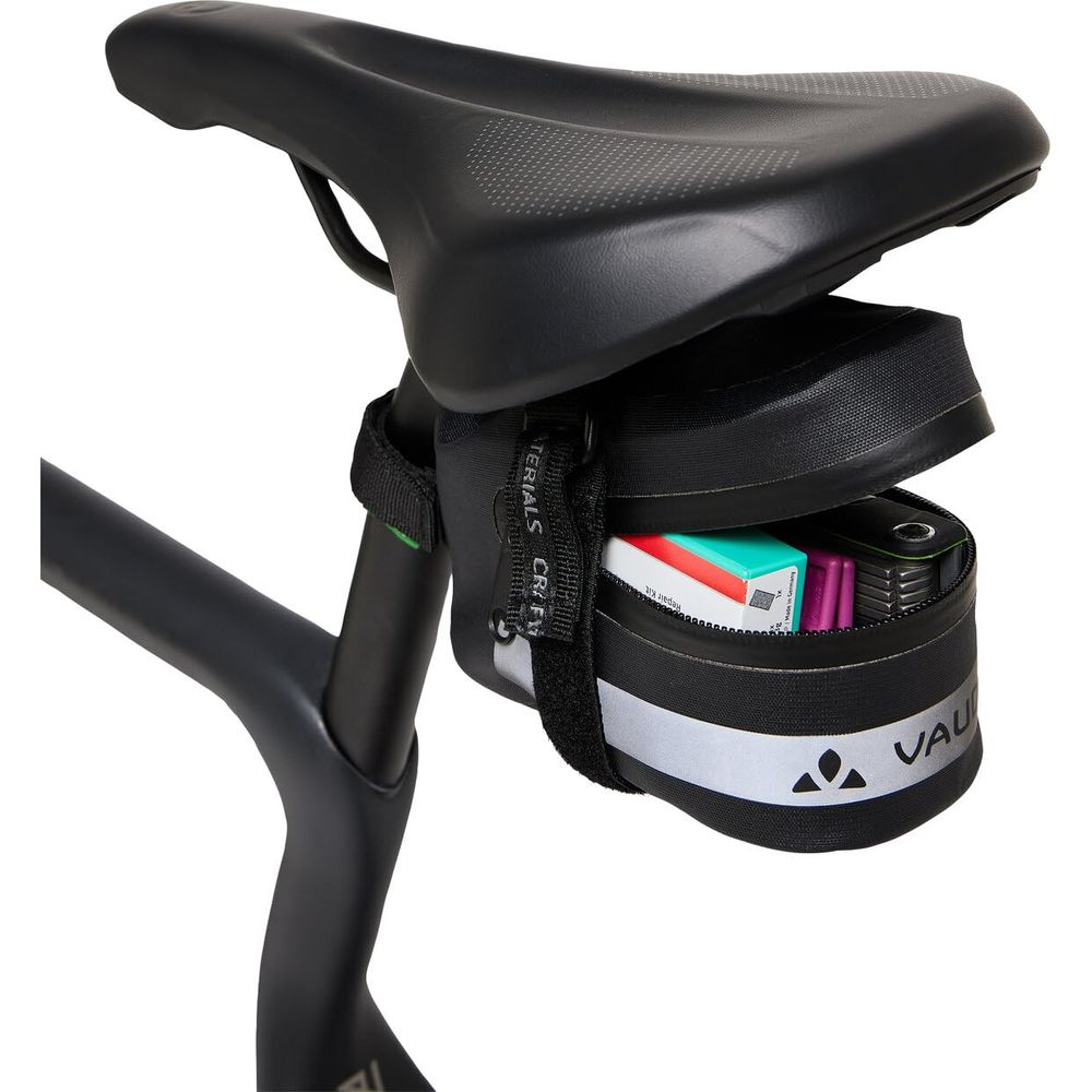 Sacoche de selle de vélo noire avec compartiment ouvert et outils de réparation.