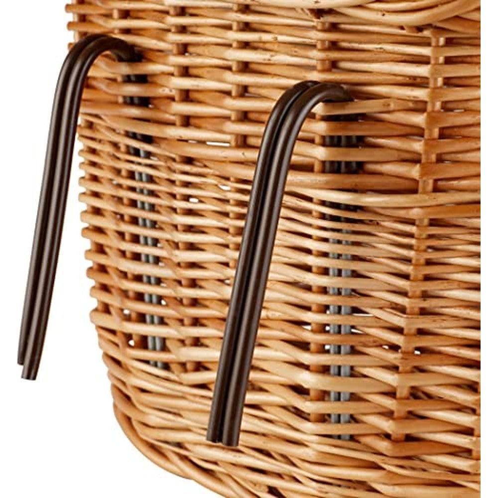 Gros plan d'un panier en osier tressé avec deux poignées métalliques courbes et sombres.